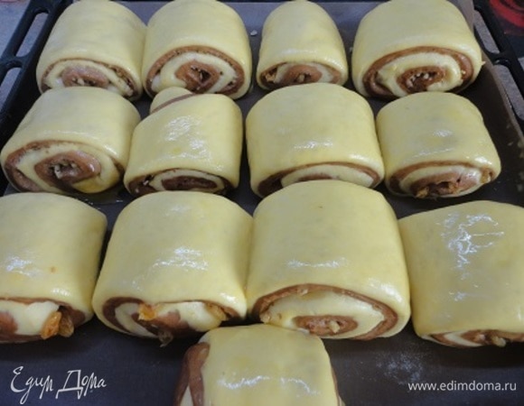 Нарезаем на кусочки по 6–7 см. Выкладываем на противень. Оставляем на расстойку. Включаем духовку для разогрева на 180°C. Поднявшиеся булочки смазываем яичным желтком.