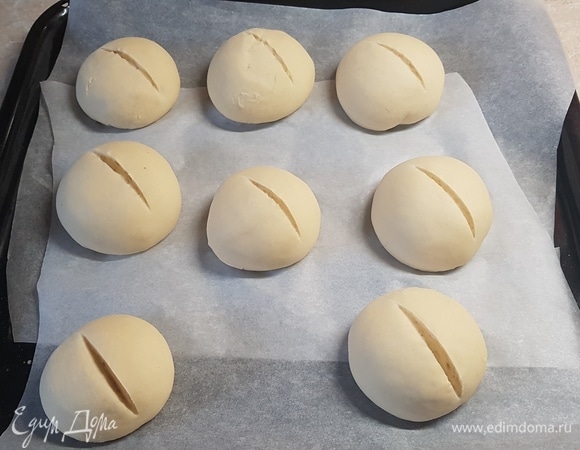 На каждой булочке сделать надрез и поставить в духовку. Выпекать первые 10 минут с паром при 240°C. Потом температуру снизить и выпекать еще 15 минут при 200°C.