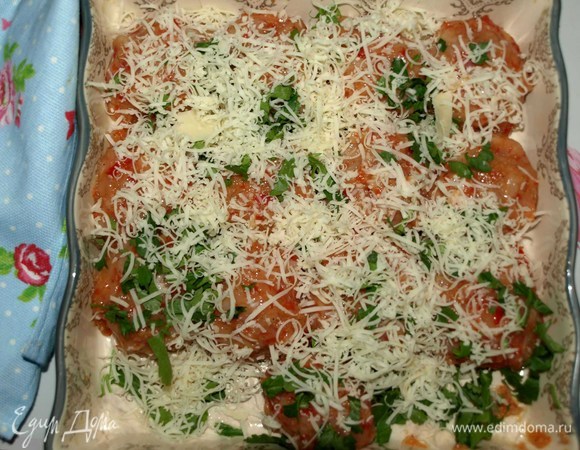 Формируем фрикадельки (при необходимости смочить руки холодной водой). Кладем в форму для запекания. Посыпаем рубленой зеленью петрушки и тертым сыром.