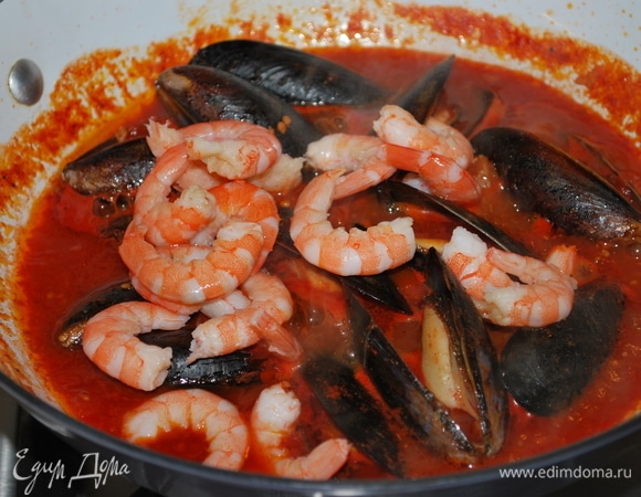 В соус добавьте мидии, закройте крышкой и все вместе проварите в течение 5 минут. Потом добавьте очищенные креветки и прогрейте все вместе в течение 2–3 минут.
