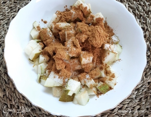 Для начинки нарезаем мелкими кубиками кисло-сладкик яблоки и грушу. В миске смешиваем кусочки фруктов, добавляем к ним сахар и корицу, перемешиваем.