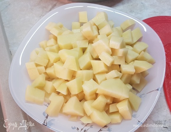 Картофель нарезать небольшим кубиком. Выложить в бульон картофель, лук и морковь. Варить до готовности картофеля.