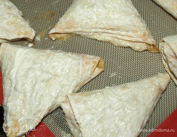 Через 30 минут достаем пирожки и смазываем их сметаной. Отправляем обратно в духовку еще на 10–15 минут.