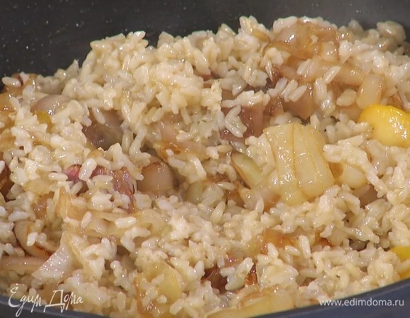 Готовый рис выложить в сковороду с луком, полить лимонным соком, оливковым маслом Extra Virgin и перемешать.