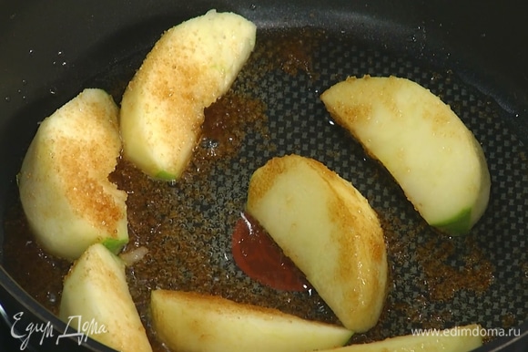 Разогреть в сковороде оливковое масло, выложить яблочные дольки, посыпать оставшимся сахаром и закарамелизировать.