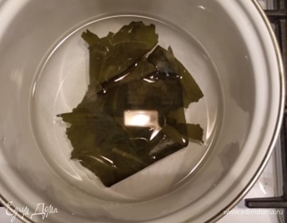 В воде замачиваем комбу минут на 20. Одновременно замачиваем водоросль вакаме в другой посуде. Когда комбу размокнет, ставим кастрюлю на огонь и почти доводим до кипения. Давать закипеть нельзя, иначе водоросль станет слишком горчить. Достаем комбу и откладываем, если хотим использовать для варки другого бульона (на следующий день, например), или выбрасываем. Кладем стружку тунца, доводим до кипения, уменьшаем огонь и варим секунд 30. Выключаем огонь, оставляем минут на 10. Когда стружка осядет, процеживаем бульон. Стружку тоже откладываем для второго бульона или выбрасываем.