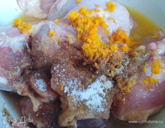 Куриные бедра поместить в миску. Из апельсина выжать сок, натереть шкурку на мелкой терке. Добавить к бедрам цедру, сок, соль, сахар, соевый соус, сушеный чеснок. Перемешать и дать мясу замариноваться в течение 30 минут, время от времени перемешивая его с маринадом.