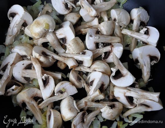 Шампиньоны нарезаем произвольно. Я режу крупно, на четыре части. При жарке они сильно уменьшатся в размере. Добавляем их в сковороду к луку. Жарим все вместе пару минут.