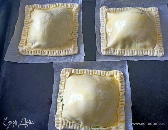 Закрепить края. Верх смазать желтком. Запекать в предварительно разогретой до 180°C духовке 15–20 минут.