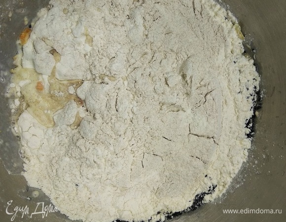 Затем засыпьте сухие ингредиенты и включите тестомешалку сначала на медленную скорость, затем — на среднюю. Вымешивать тесто необходимо не менее 10 минут. Это можно сделать и руками.