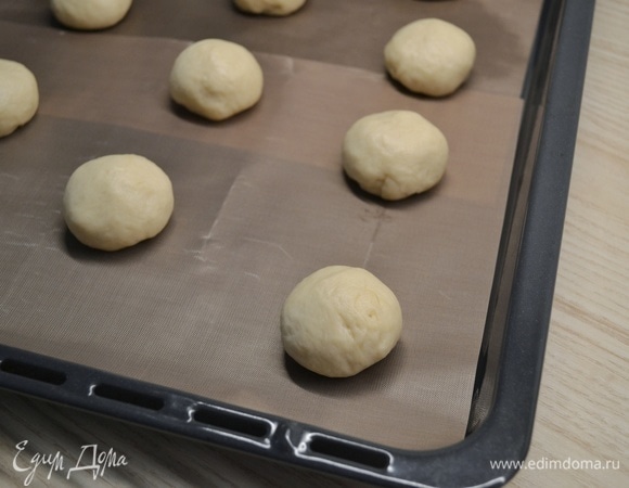 Тесто разделить на кусочки по 45–50 г, из каждого кусочка сформировать шарик. Накрыть полотенцем и убрать в теплое место на 30 минут.