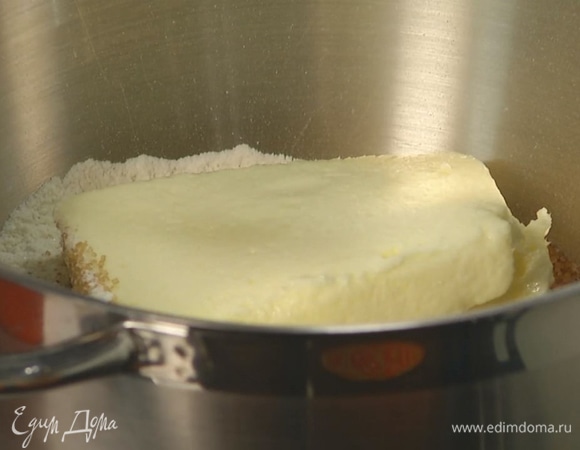 В чашу комбайна всыпать муку, добавить дрожжи, сахар, соль и предварительно размягченное сливочное масло и вымешивать на маленькой скорости насадкой-крюком.