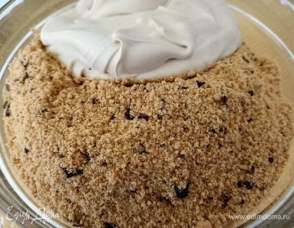 Отложить две столовые ложки крема для украшения. Остальной смешать с крошкой.