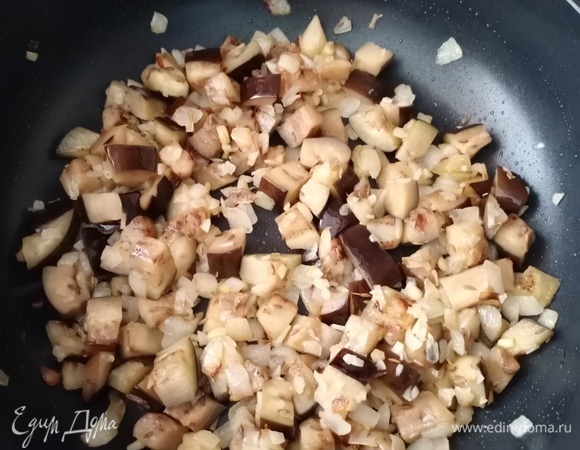 Отправляем к луку с чесноком баклажаны, обжариваем минут 5.