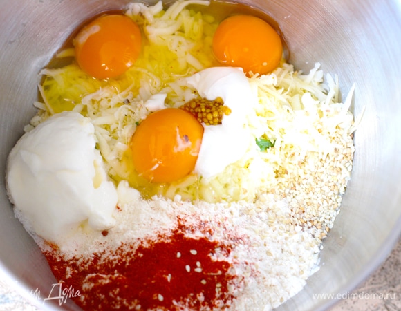 В дежу миксера (я замешиваю в планетарке лопаткой) выложить сыр, добавить приправы, яйца, муку, соль, зелень и сметану, смешать до объединения.