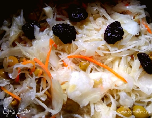 На дно чаши мультиварки налить масло и всыпать перец. Засыпать капусту, оливки, чернослив. Если чернослив очень крупный, то нарезать на 2–4 части. Все перемешать и закрыть крышку.