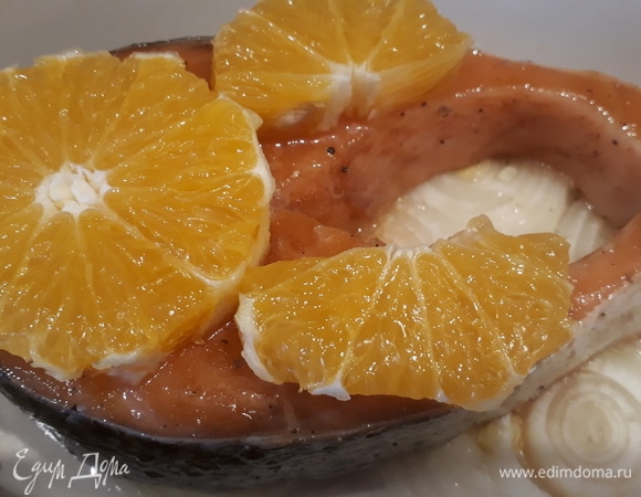 Очищаем 2 дольки апельсина и кладем их на семгу.