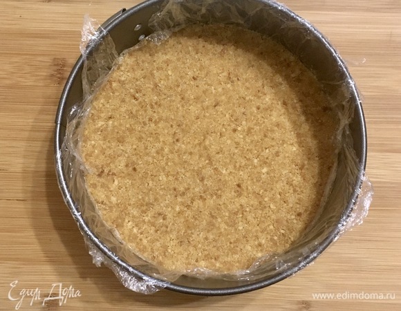 Соединяем печенье и масло, перемешиваем. Выкладываем в форму, предварительно застеленную бумагой для выпечки, формируем бортики и дно (я выложила без бортика). Ставим готовую форму в холодильник на 30 минут, она должна хорошо застыть.