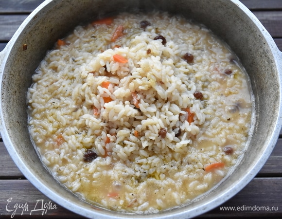 Всыпать рис с изюмом и влить воду. На сильном огне довести до кипения. Когда уровень воды достигнет уровня крупы, собрать рис с краев горкой в центре.