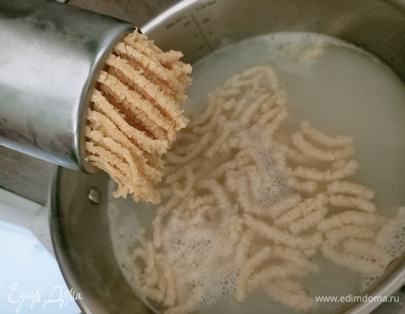 Тесто разделить на три части — так будет удобнее с ним работать. Поместить в пресс и продавить тесто в кипящий бульон. Длина жгутиков должна быть не менее 3–4 см.