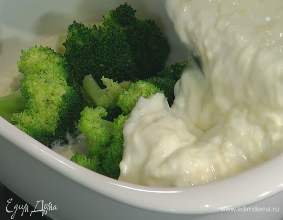 В форму для запекания влить половину соуса бешамель, затем выложить брокколи, залить второй половиной соуса и посыпать оставшимся сыром.   