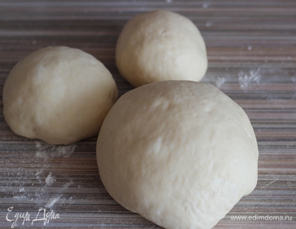 Делим тесто на несколько частей: самая большая — для основы и две поменьше — для украшения. Округляем кусочки, накрываем полотенцем и оставляем еще на 10 минут.