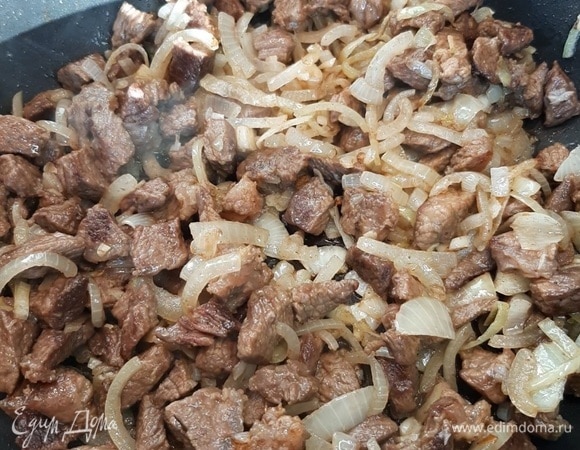 Репчатый лук нарезаем произвольно. Отправляем его к мясу и слегка обжариваем.