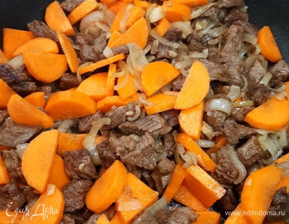 Морковь нарезаем полукольцами средней толщины и отправляем ее к мясу, поджариваем пару минут.