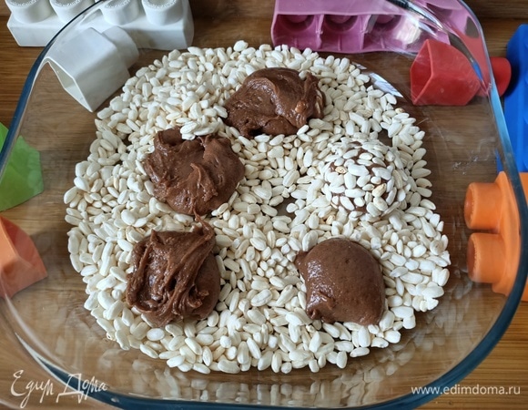 В миску насыпать воздушный рис. С помощью ложки выложить небольшими порциями тесто и сформировать шарики.