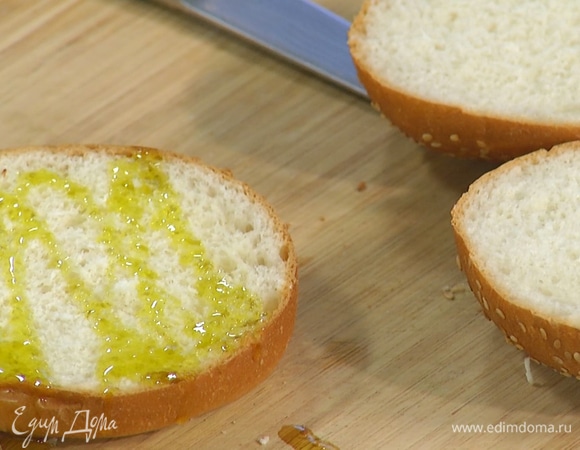 Булочки для бургера разрезать пополам, нижнюю часть смазать оливковым маслом.