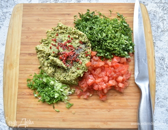 Мелко нарезать помидор, предварительно удалив из него жидкую часть с семенами. Измельчить зеленый лук, кинзу, красный острый перец.