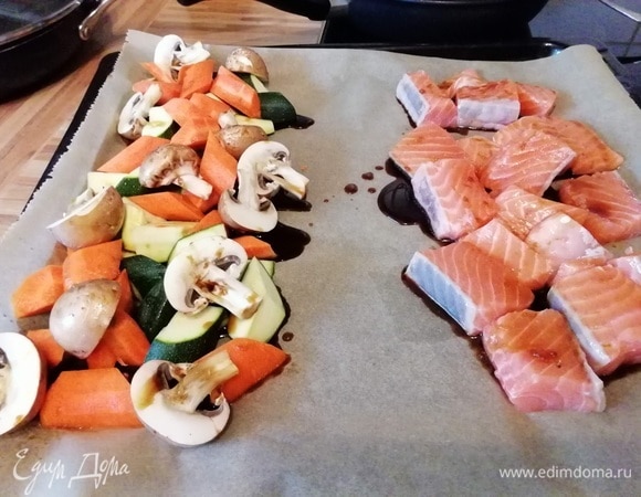 Разогреть духовку до 200°C. Смешать мед или сироп агавы с соевым соусом, кунжутным маслом и соком лайма. Очистить, вымыть и нарезать морковь и цукини брусочками. Грибы очистить и нарезать на половинки. На одну сторону противня выложить овощи, полить несколькими ложками маринада. Филе лосося вымыть, обсушить и нарезать на кусочки. Выложить лосося на другую половину противня, полить маринадом и отправить в духовку на 10 минут. Овощи получаются еще хрустящими, а лосось не пересушенным.