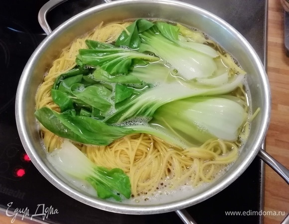 Сварить лапшу (подойдет любая по вашему вкусу, если нет азиатской, то подойдут даже спагетти). За несколько минут до конца варки выложить в кастрюлю пак-чой. Затем откинуть на дуршлаг и дать стечь жидкости. Если у вас соба, то ее следует промыть под холодной водой.