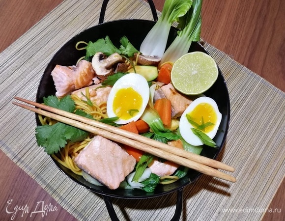 Теперь можно сервировать. Боулы традиционно подают в больших глубоких пиалах. Выложить лапшу с овощами, сверху — кусочки лосося, половинки яиц, затем посыпать свежей кинзой и зеленым луком. Добавить жареный арахис.