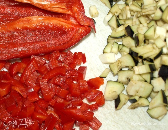 В ингредиентах указан вес подготовленных овощей. Баклажаны (по желанию очистить от кожуры) мелко нарезать, предварительно удалить плодоножку. Красный сладкий перец очистить от плодоножки и перегородок, мелко нарезать.