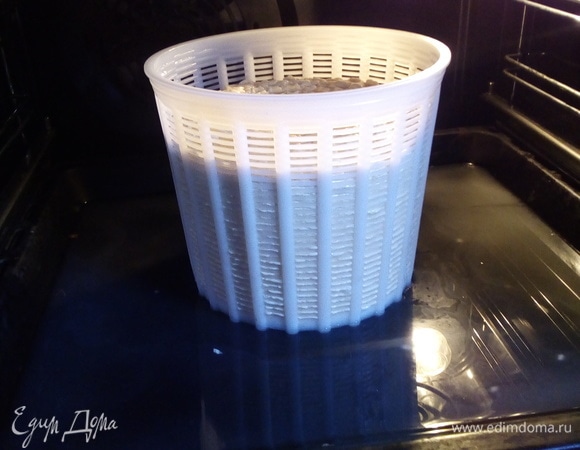 Через полчаса достать из духовки, перевернуть, слить сыворотку с противня. Еще раз прогреть духовку до 50°C и поставить еще на полчаса. Через полчаса сыр опять перевернуть, слить сыворотку с противня, но духовку не прогревать. Поставить еще на полчаса.