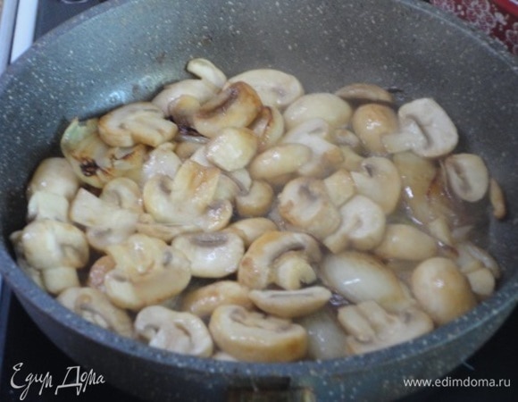 Затем добавить нарезанные дольками шампиньоны и продолжить жарить до золотистости. Влить в сковороду бульон от фасоли и довести до кипения. Снять с огня.