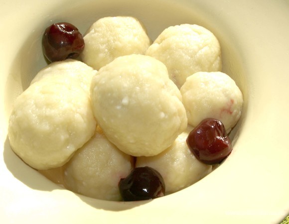 Готовые вареники откидываем в дуршлаг, даем стечь воде. Перекладываем в тарелки. Сразу подаем. Добавляем по желанию сливочное масло. Можно полить вишневым сиропом, подать сметану.