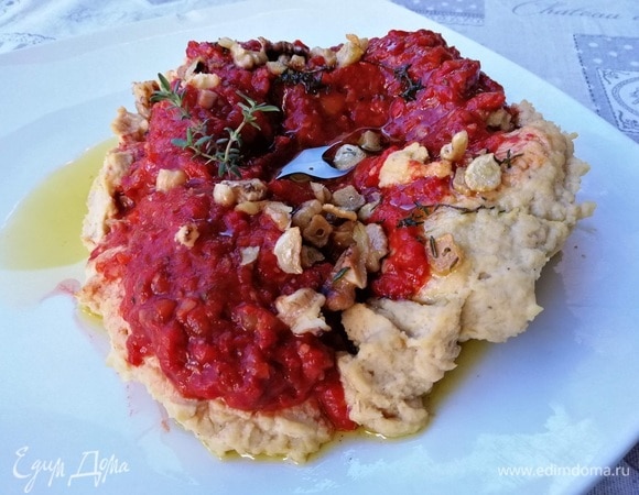 Разложить хумус на тарелку и сформировать плоскую полость с ложбинкой посередине. Выложить в лунку пасту из жареного перца, полить тимьяново-оливковым маслом, посыпать грецкими орехами.