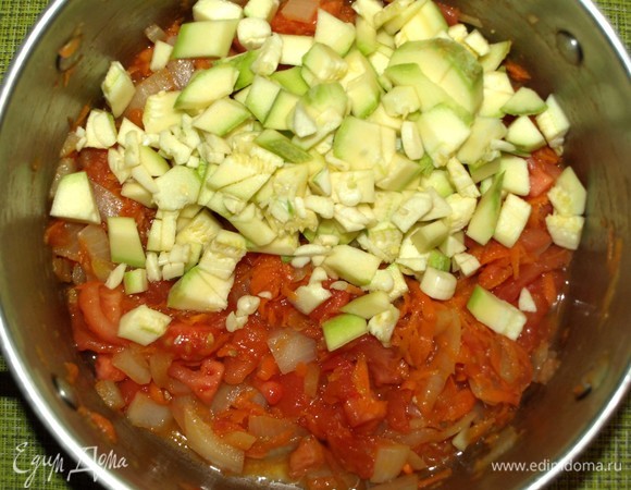 Добавляем в кастрюлю нарезанные кабачки и порубленный чеснок. Перемешиваем и готовим 10 минут. Не забываем помешивать овощи.