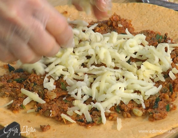 На две тортильи тонким слоем равномерно выложить начинку, посыпать натертым сыром, затем накрыть лепешкой без начинки и прижать.