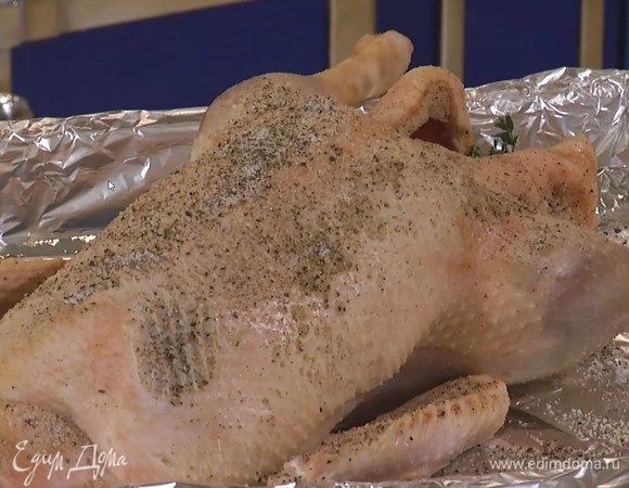 Выстелить глубокий противень двойным слоем фольги, выложить тушку, поперчить и посолить со всех сторон, внутрь поместить нарезанное яблоко, лук, лавровые листья, тимьян, сердечки и желудочки.