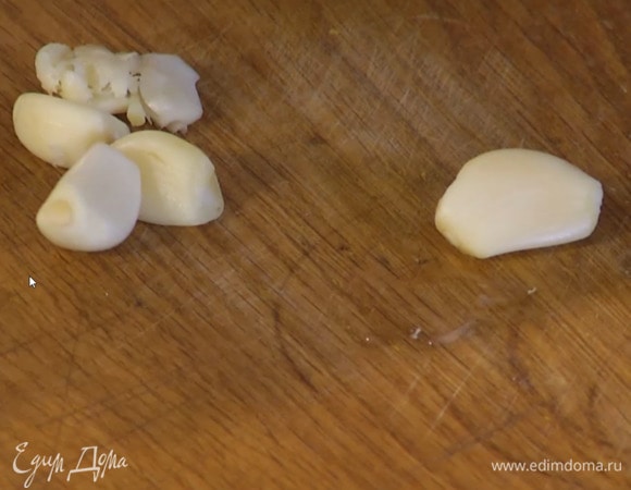 Чеснок почистить, раздавить плоской стороной ножа и добавить в сковороду с луком, все слегка посолить и перемешать.