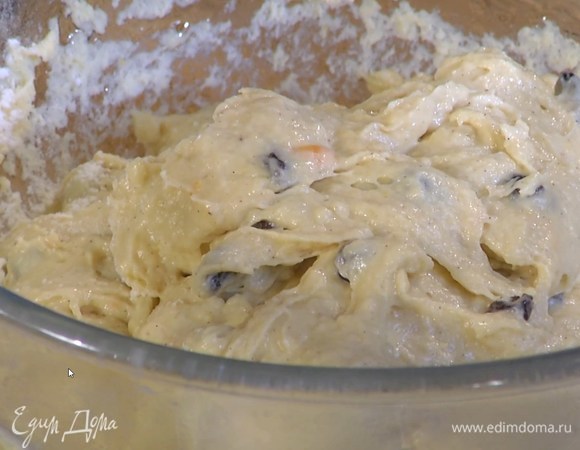 Не выключая комбайна, небольшими порциями ввести предварительно размягченное сливочное масло, всыпать изюм, цедру апельсина и вымешать тесто.