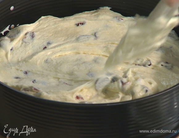 Разъемную форму застелить бумагой для выпечки, выложить тесто и равномерно распределить.