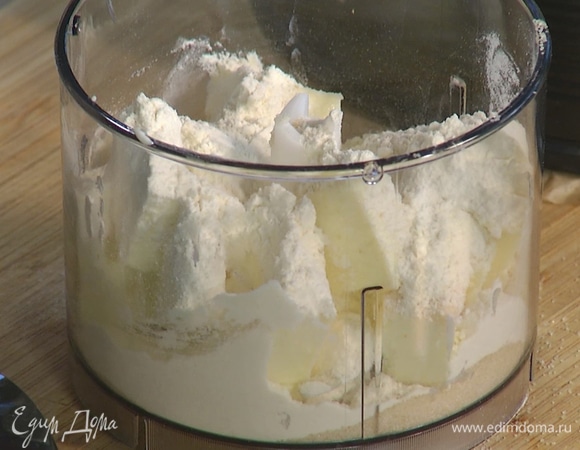 Предварительно охлажденное оставшееся сливочное масло порезать на небольшие кусочки и выложить в чашу блендера, добавить сахар, муку и измельчить все в крошку.
