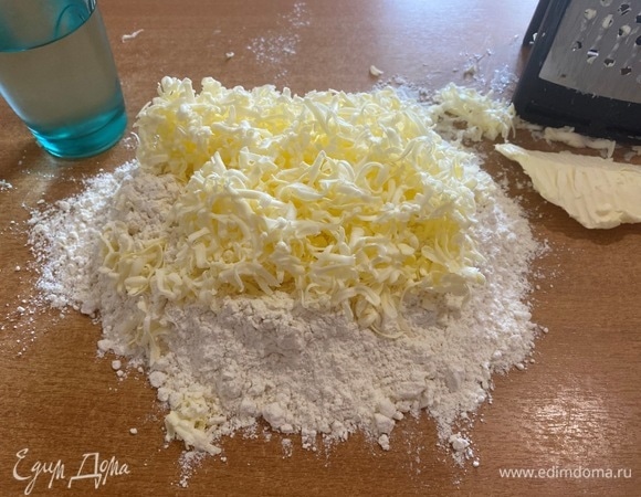 Замороженное сливочное масло (можно заменить маргарином) натереть на крупной терке, соединить с мукой и порубить ножом.
