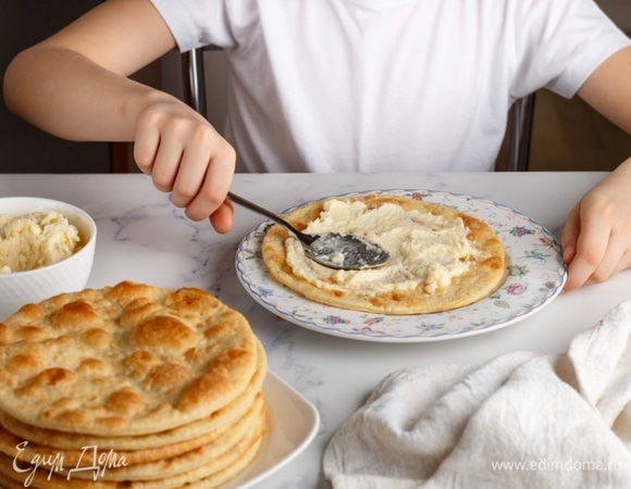 Торт собирал мой маленький помощник. Первый корж смазываем кремом. Крем размазываем очень тонко. Это позволит коржам остаться хрустящими.
