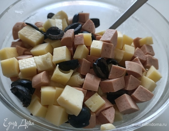 Для начинки нарезать кубиками сыр, черные оливки и сосиски.