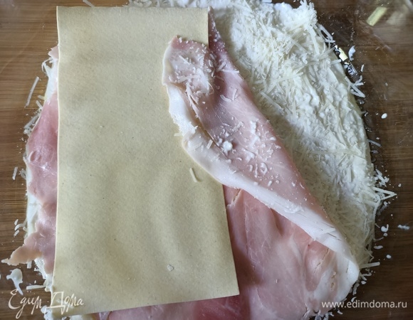 На крем выложить листы лазаньи. Затем — слой крема, тертый сыр и ветчина.